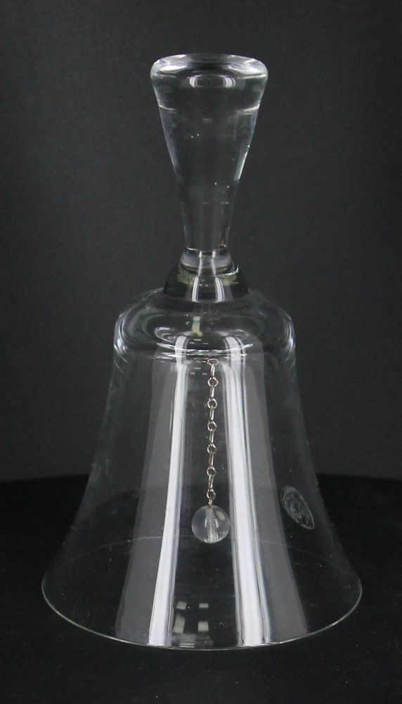 Колокольчик стеклянный традиционной формы, язычок в форме шара на металлической цепочке. Ручка простой формы расширяется кверху. Поверхность гладкая. Высота 14 см.